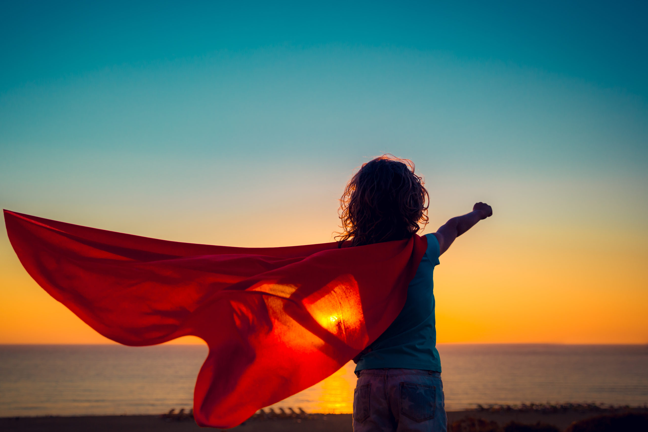 Superhero child on the beach. Summer vacation concept